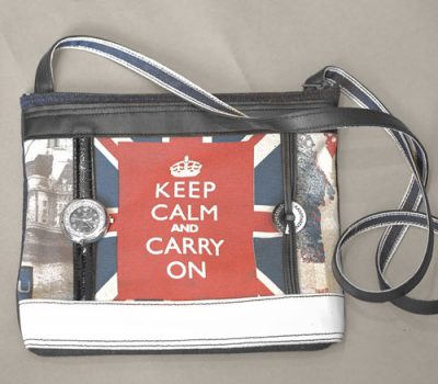 Sac qui donne l'heure en tissus style anglais avec le drapeau et marqué "keep calm and carry on" sur font rouge, structure en cuir noir et blanc avec montre en cuir cousu et le logo cousu