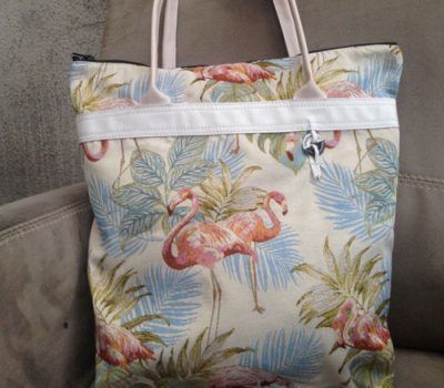 Sac Cabas en tissus blanc cassé avec des motifs de fleur au teint léger et des flamants rose avec des poignés en cuir blanc et le logo akapparence cousu par des lacets en cuir